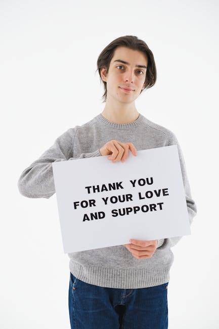 顯化感恩 高效提升幸福感與實現目標的秘訣 A young man in a sweater holds a Thank You sign on a white background, expressing gratitude.